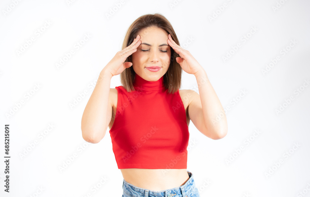 Studio shot of serious young caucasian woman holding fingers on her temples with concentrated and focused expression Studio shot of serious young caucasian woman holding fingers on her temples with concentrated and focused expression