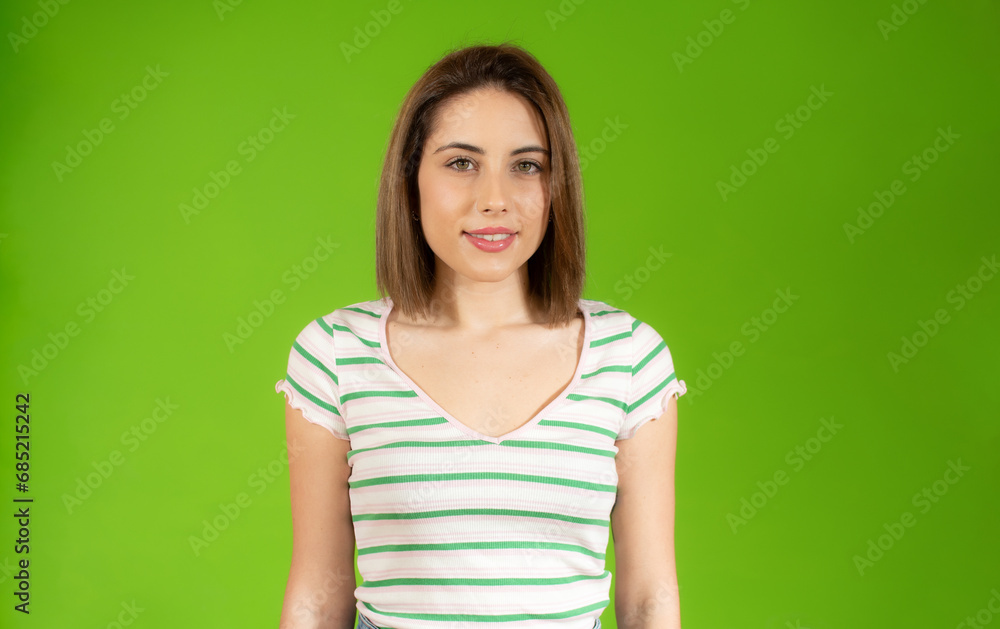 Portrait of young beautiful woman wearing casual t-shirt smiling looking at camera over green background. Portrait of young beautiful woman wearing casual t-shirt smiling looking at camera over green background.