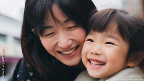 Happy Asian Mother and Daughter Smiling Together Outdoors Closeup Portrait