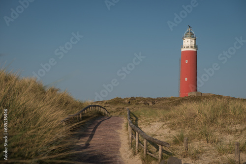 red lighthouse on the dunes near ocean on Texel island in the Netherlands photo