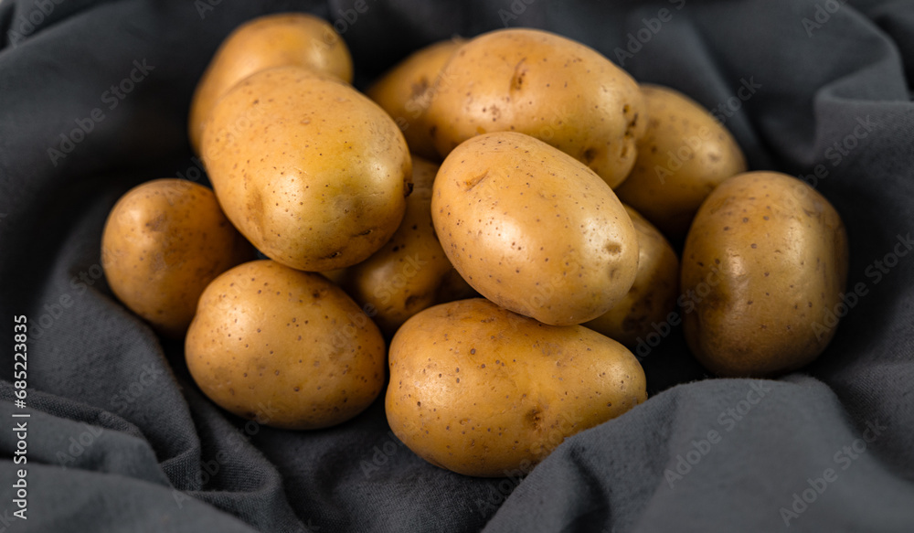 Potatoes are lying on a gray cloth in close-up