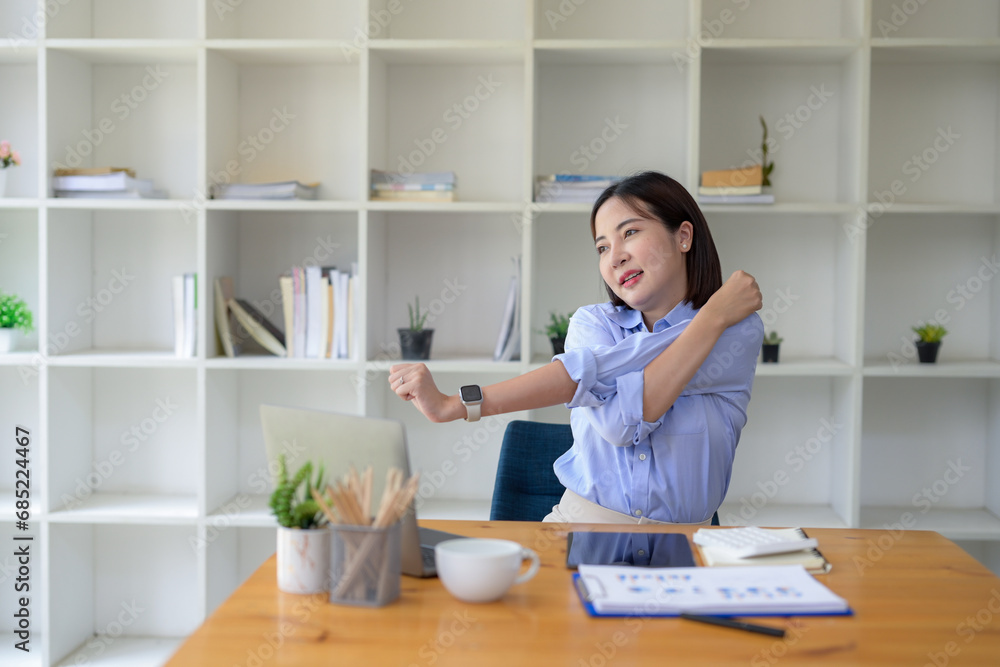 Businesswoman stretching lazy at the desk to relax while working in the office. Feeling stressed and achy from work. Businesswoman stretching lazy at the desk to relax while working in the office. Feeling stressed and achy from work.