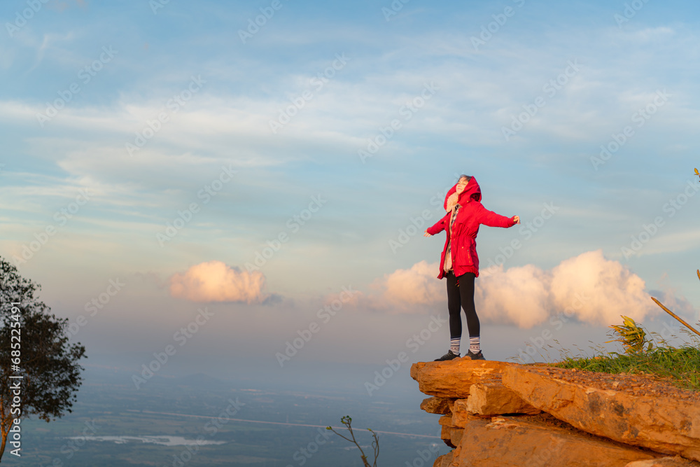 Obraz premium Portrait of a beautiful young woman in red coat on the background of blue sky