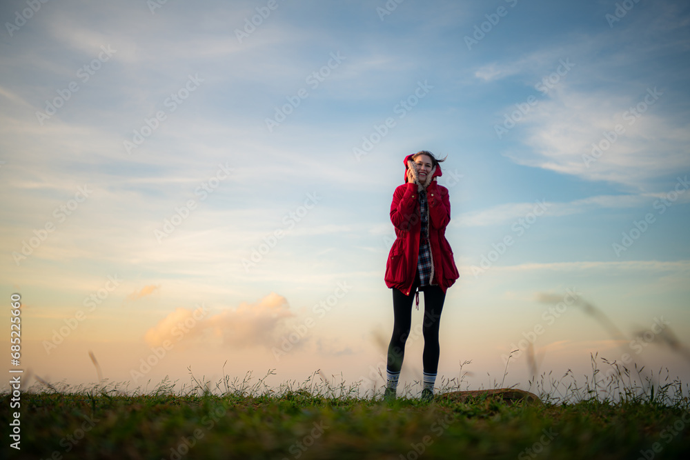 Portrait of a beautiful young woman in red coat on the background of blue sky Portrait of a beautiful young woman in red coat on the background of blue sky