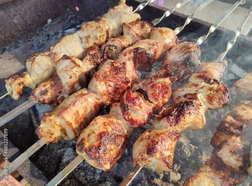 Juicy toasted barbecue on the grill close-up. A set of skewers with pieces of delicious and fragrant meat. Frying pork or beef on hot coals. Meat dish at a picnic. Cooking Shish kebab outdoor