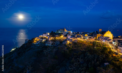 Full moon over Forza d'Agro and coastline, Messina, Sicily, Italy photo