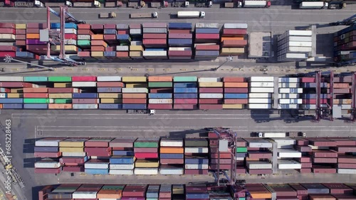Stacked cargo containers top down aerial view. Containers at logistics terminal. Cargo container outdoor warehouse 