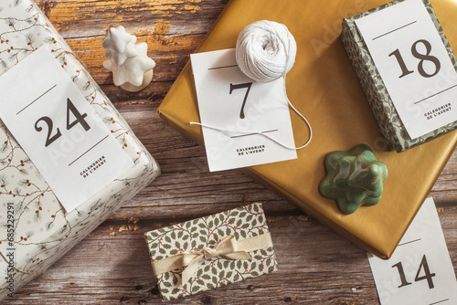 Overhead view of gifts for an advent calendar next to Christmas decorations photo