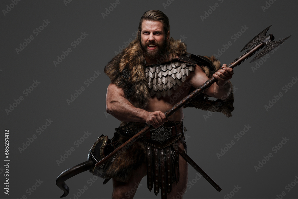 Fierce, bearded Viking warrior dressed in fur and light armor, holding a large two-handed axe, shouting against a grey background Fierce, bearded Viking warrior dressed in fur and light armor, holding a large two-handed axe, shouting against a grey background