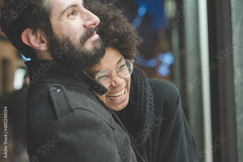 young multiethnic couple hugging outdoor smiling having fun laughing