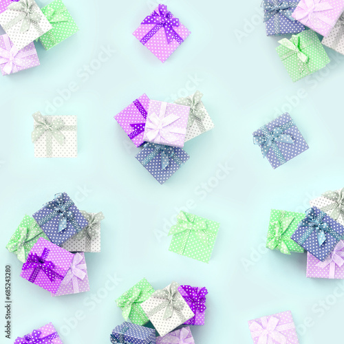 Piles of a small colored gift boxes with ribbons lies on a violet background. Minimalism flat lay top view pattern.