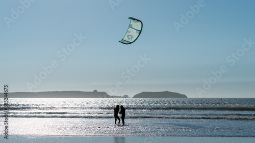 Silhouette of an unidentified couple getting ready to do kitesurfing at the beach of Essaouira, Morocco, which offers a perfect blend of wind and waves, attracting surf enthusiasts from around the wor