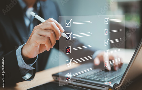 Document management system DMS. Business assessment form, questionnaire, checklist audit task form. Businessman work on laptop computer checklist and fill survey form online. Wrong and right survice . photo