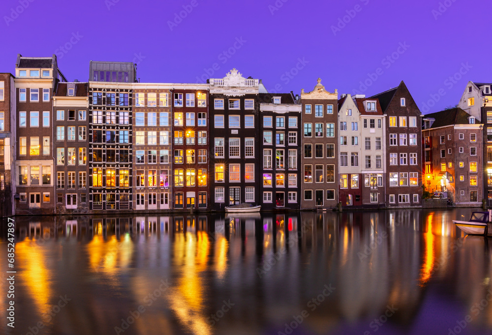 Amsterdam architecture on Damrak canal at night, Netherlands