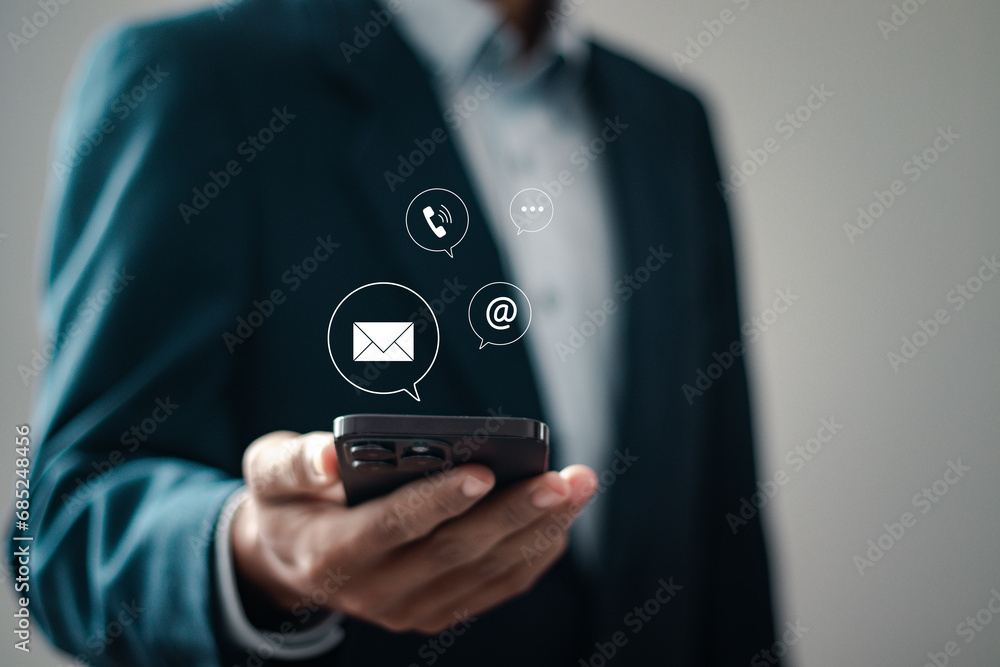 Contact us concept. Businessman using smartphone with contact us icon or Customer support hotline people connect. Contact us concept. Businessman using smartphone with contact us icon or Customer support hotline people connect.
