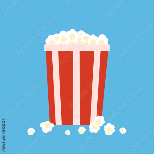 White popcorn flakes in striped bucket on blue background. Full pop corn pack. red striped pop corn box. Yummy crunchy movie snack. Tasty cinema food product.
