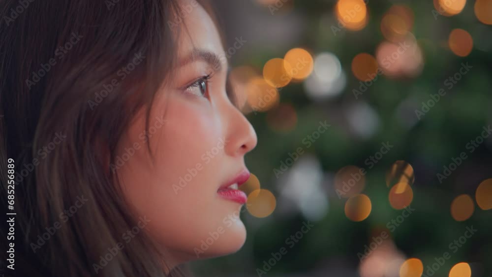 Attractive woman face looking looking towards the window against the background of the Christmas tree bokeh light, Christmas and new year holiday. Attractive woman face looking looking towards the window against the background of the Christmas tree bokeh light, Christmas and new year holiday.