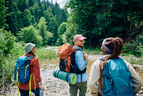 Tableau sur toile Group of happy backpackers taking walk through mountain.