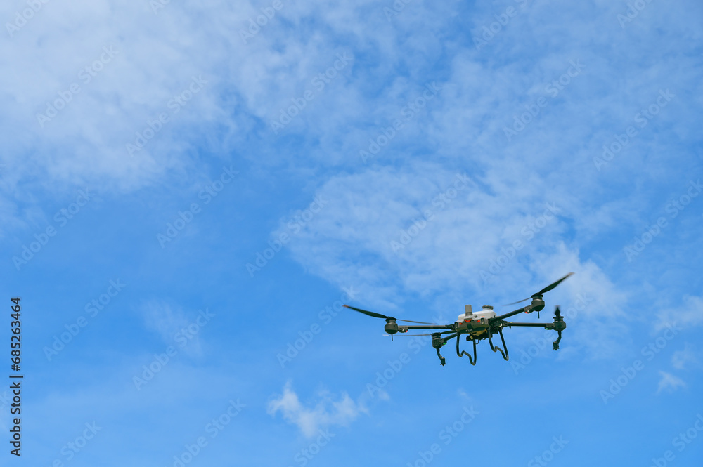 Fototapeta premium Agriculture drone flying to sprayed fertilizer is agricultural smart farm business concept