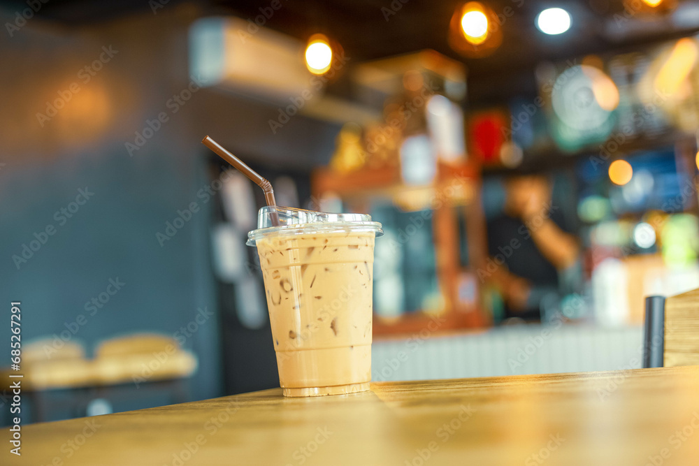Glass of coffee milk on wooden table, With coffee cafe background. Cold  espresso beverage tasty. Refreshment food.