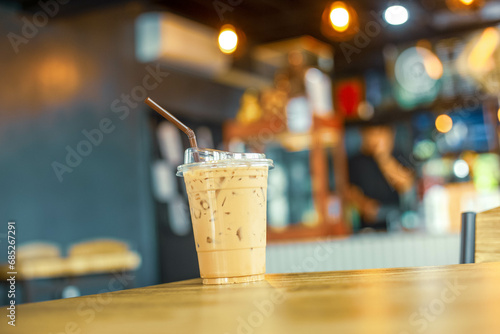 Glass of coffee milk on wooden table, With coffee cafe background. Cold  espresso beverage tasty. Refreshment food. © Boykowit