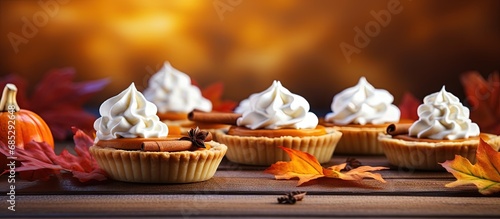 Thanksgiving mini pies with pumpkin leaf and cream toppings copy space image