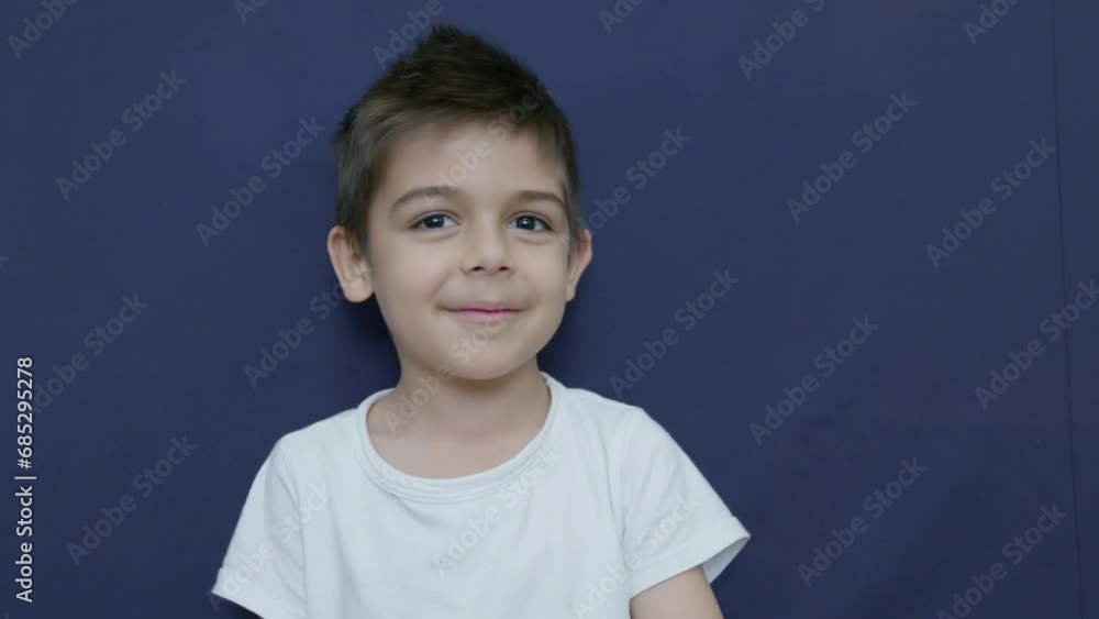 Disagreement. Caucasian child boy shaking his head and making funny angry face expressions. Slow motion, isolated on blue background. High quality 4k footage Disagreement. Caucasian child boy shaking his head and making funny angry face expressions. Slow motion, isolated on blue background. High quality 4k footage