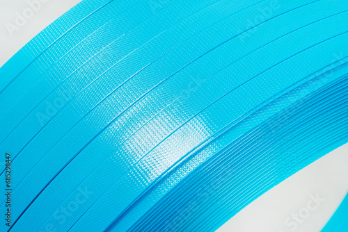 blue polyester tape on a white background. high-strength temoplastic tape in a roll on a light background. tape packaging material in roll