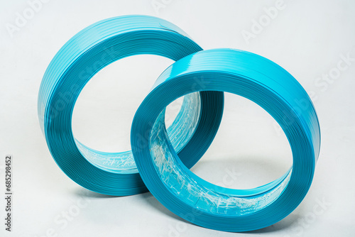 blue polyester tape on a white background. high-strength temoplastic tape in a roll on a light background. tape packaging material in roll