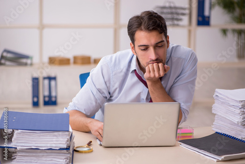 Young male employee and too much work in the office