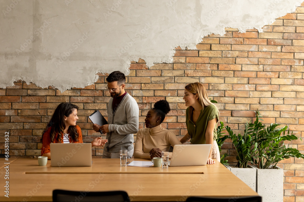 Young multiethnic startup team working by the brick wall in the industrial style office Young multiethnic startup team working by the brick wall in the industrial style office