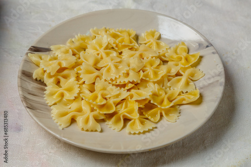Al dente farfalle pasta on a light plate on the table