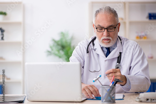 Old male doctor working in the clinic