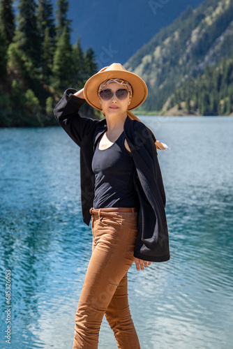 Woman tourist vertical portrait look at camera on Kolsay lake in Kolsai Koldery gorge, nature of Kazakhstan National Park. photo