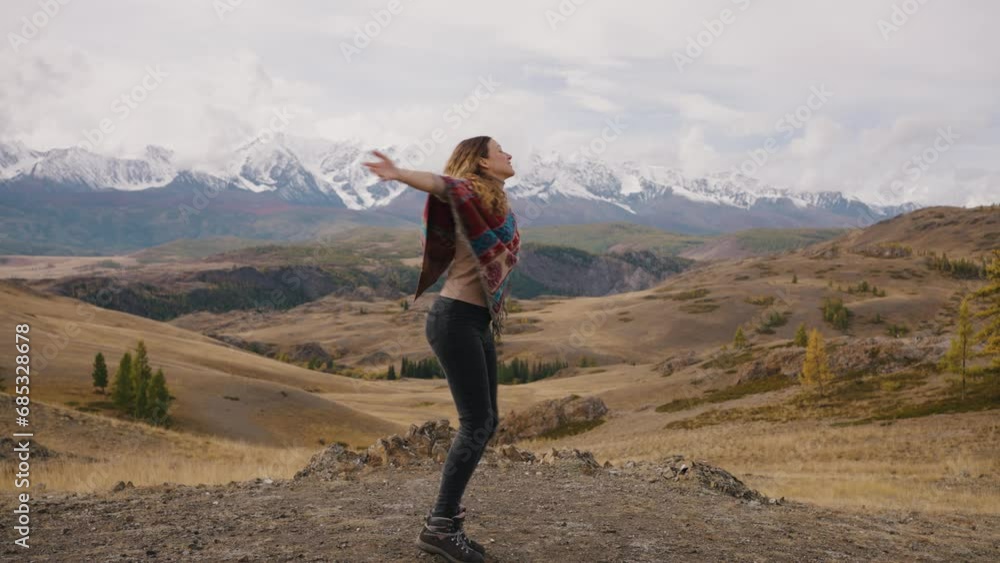 Happy girl spinning on axis cheerfully joyfully. Epic snowy mountains in background. Happy girl spinning on axis cheerfully joyfully. Epic snowy mountains in background.
