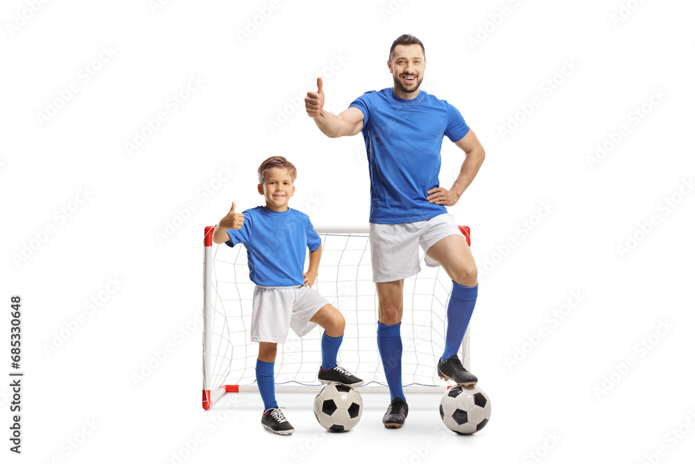 Man and boy in front of a goal gesturing thumbs up