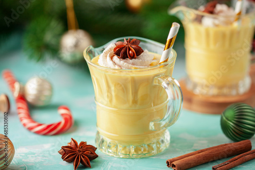 Christmas Bombardino cocktail with egg liqueur and rum. Wooden color background with christmas decorations photo