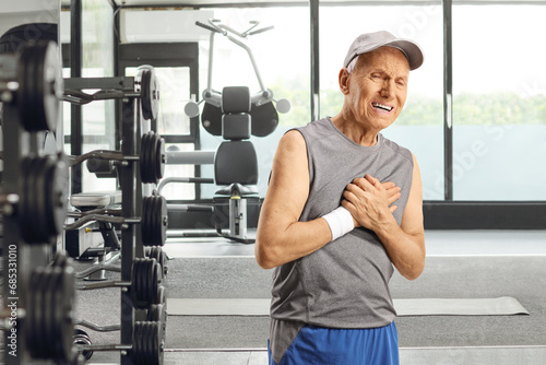 Elderly man in sportswear experiencing chest pain at a gym