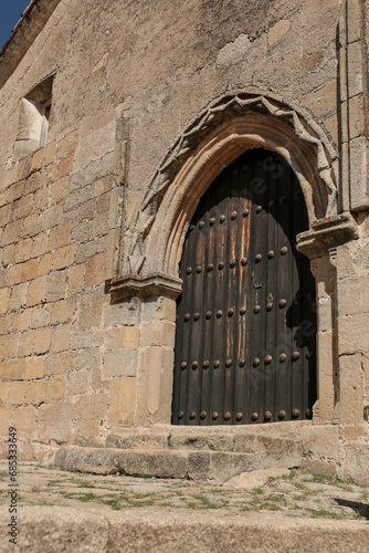 Facade of historic house with beautiful door and carved stone details in Trujillo town © SoniaBonet