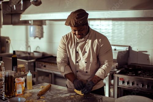 Professional chef preparing dough in restaurant kitchen photo