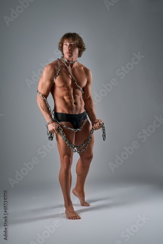 Shirtless modern gladiator with chains all over his body