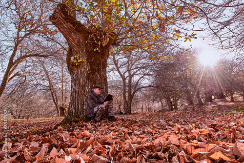 hombre adulto en un bosque de castaños con un ambiente otoñal 