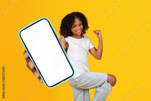 African Teenager Girl Showing Large Cell Phone Blank Screen, Studio