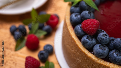 fresh blueberries and raspberries and mint leaves decorated cheesecake close-up. Confectionery, baking, bright colors	
