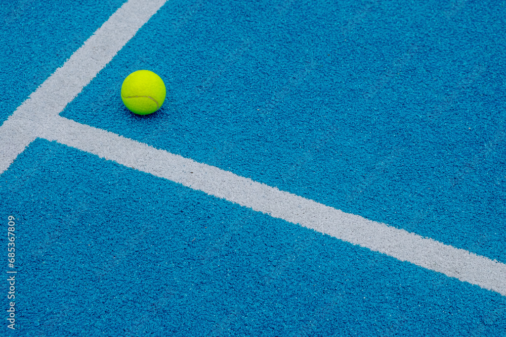 blue paddle tennis court with a ball on the surface, racket sports courts concept