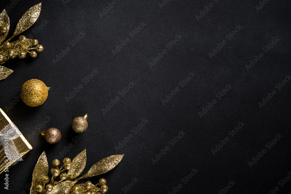 Naklejka premium Christmas gold decorations on black. Flat lay image with copy space.