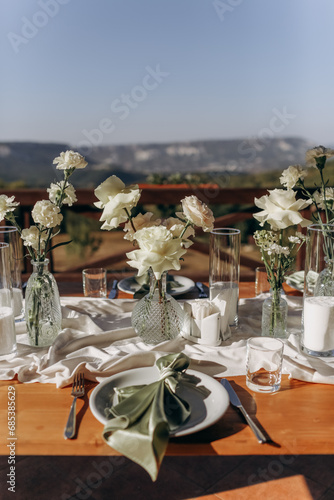 The wedding table decorated with fresh flowers. 