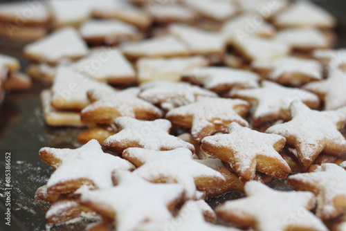 biscoitos em formato de estrelas para o natal, assados e recheados com doce de leite e cobertos com acucar de confeiteiro para a mesa das festas de fim de ano. photo