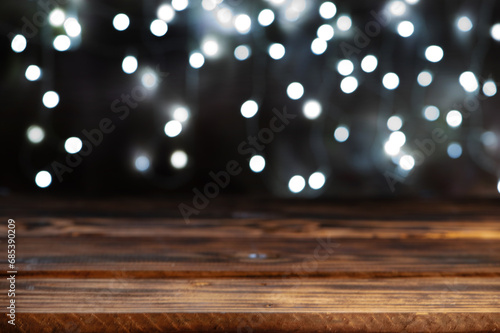Rustic wooden table, Empty rustic wooden table with blurred Christmas lights in the background, dark background, selective focus.