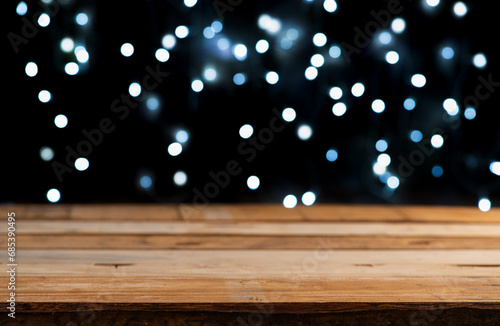 Rustic wooden table, Empty rustic wooden table with blurred Christmas lights in the background, dark background, selective focus.
